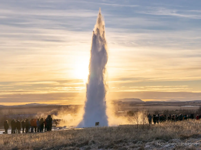 The erupting hot spring of Geysir in Iceland during a sunrise