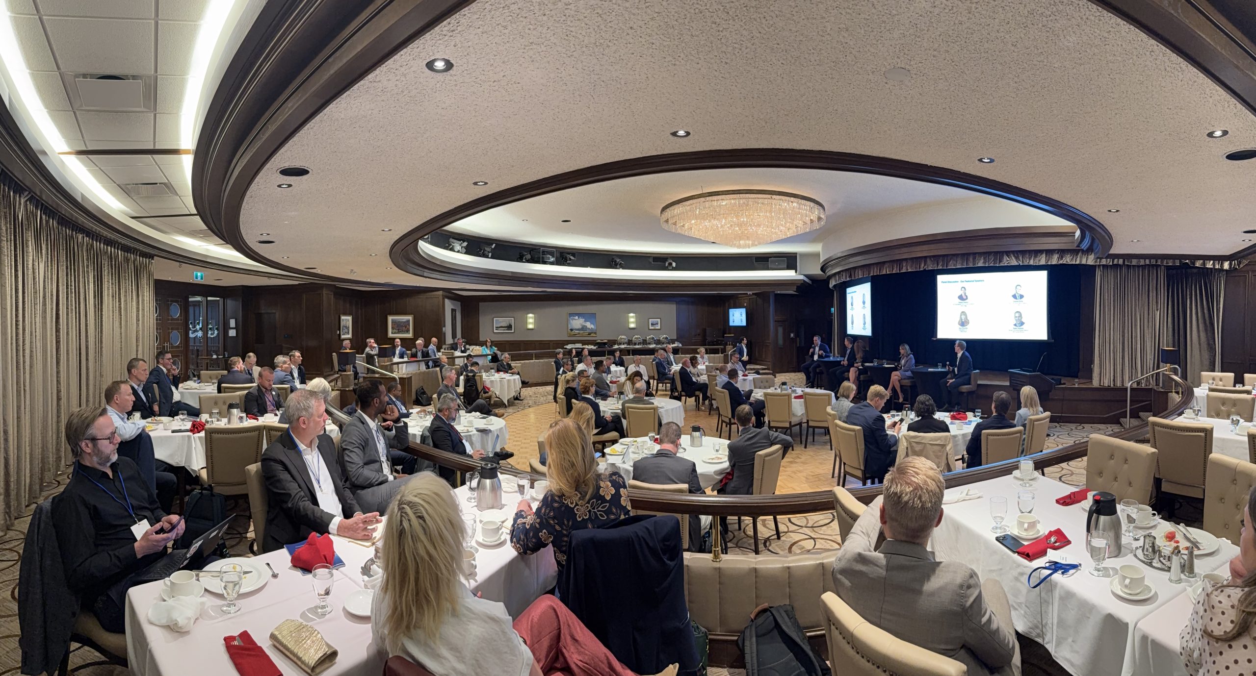 2026_WGC_RystadTGE_breakfastmeeting1 | ThinkGeoEnergy - Geothermal News & Insights Conference banquet hall with round tables, attendees, and a panel on stage presenting with screens in the background.
