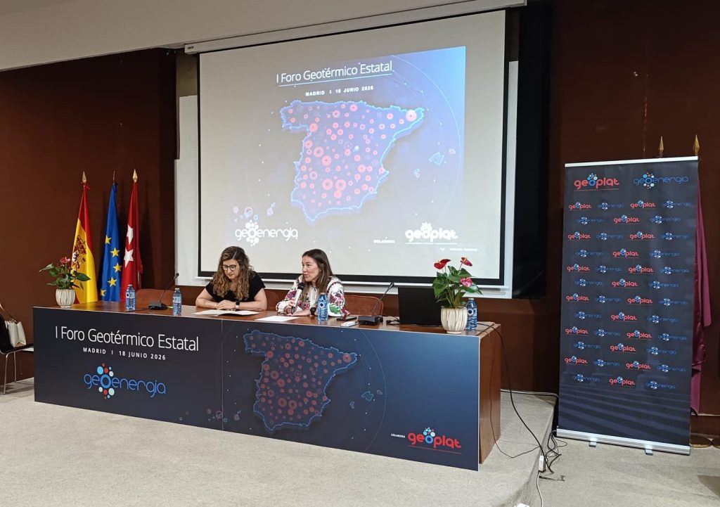 GEOENERGIA Inauguración 2 - Carmen López y Margarita de Gregorio | ThinkGeoEnergy - Geothermal News & Insights Panelists seated at a conference desk during I Foro Geotérmico Estatal in Madrid, with a map of Spain projected behind them and red data dots visible.